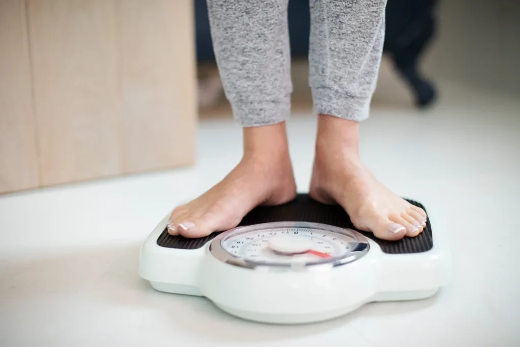 Person standing on bathroom scale at Belfast Private GP in Belfast