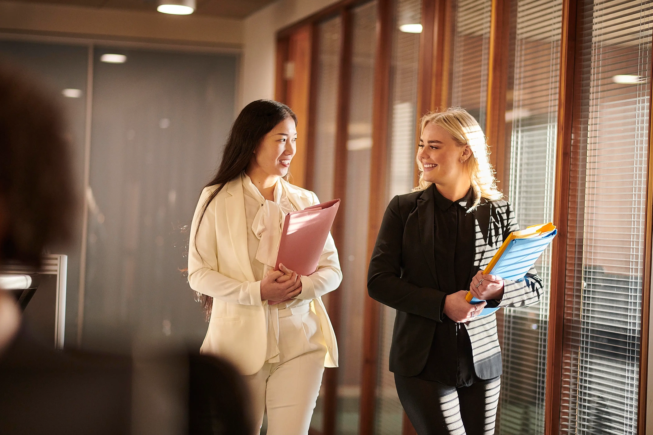Two professionals walking with folders in office at Belfast Private GP in Belfast